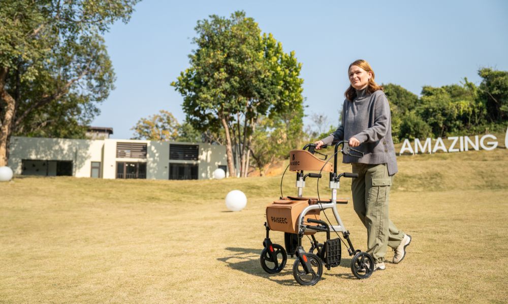 Woman pushing 4 wheel walker on grass