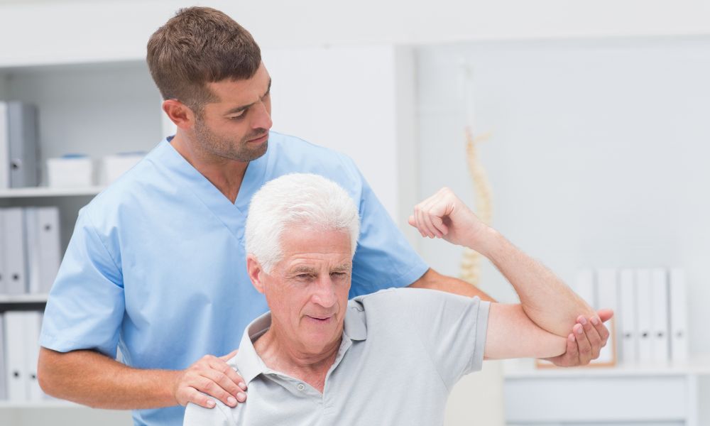 Physiotherapist is doing physical therapy for the elderly