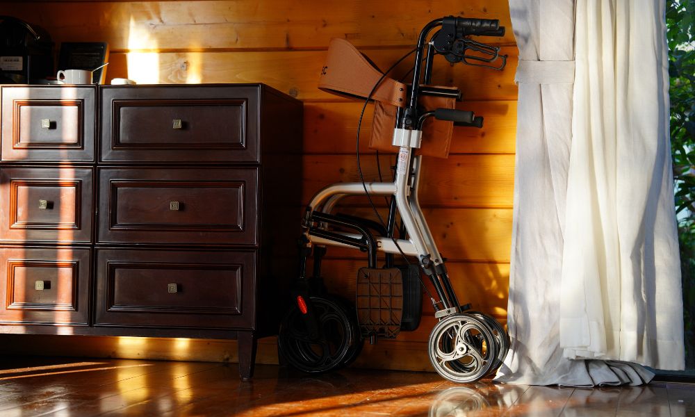 A 4-wheeled walker that folds up and sits against a wall
