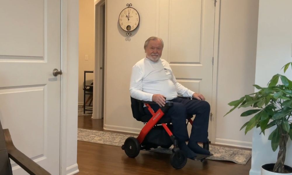 Elderly man driving a portable wheelchair indoors