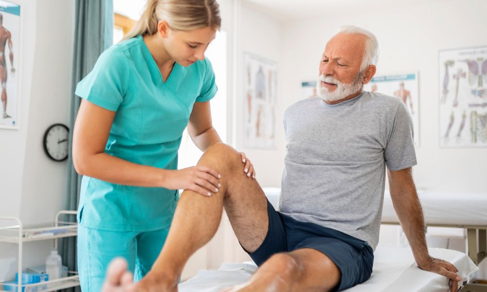 Physiotherapist examining man's knee